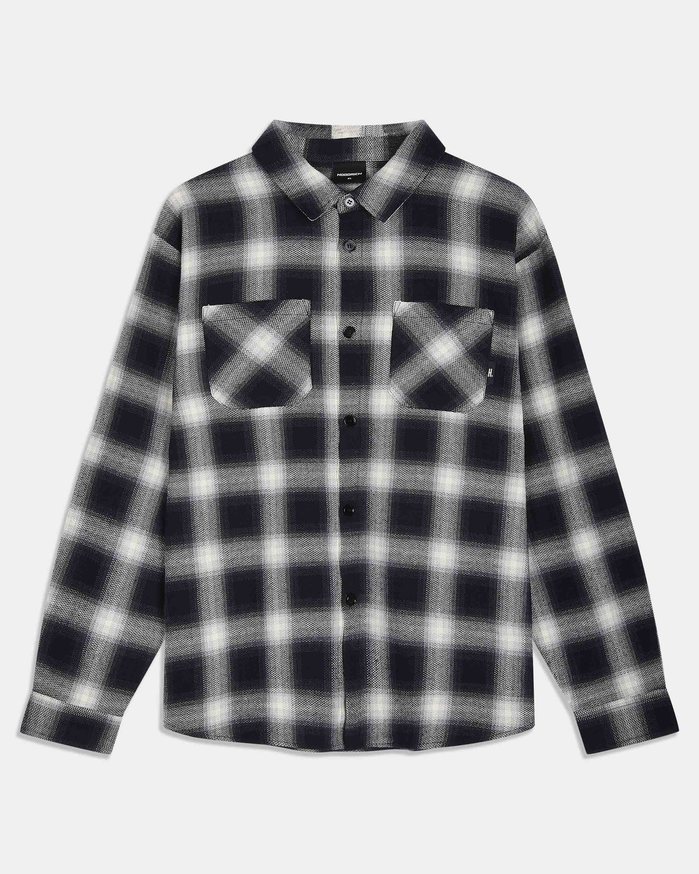 A long-sleeve button-up flannel shirt with a black and white plaid pattern, featuring two buttoned chest pockets, shown against a light gray background.