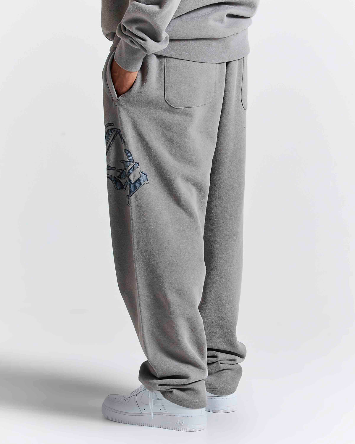 Displays a model wearing the Grey 'Hoodrich' branded men's Inkfall Full Tracksuit