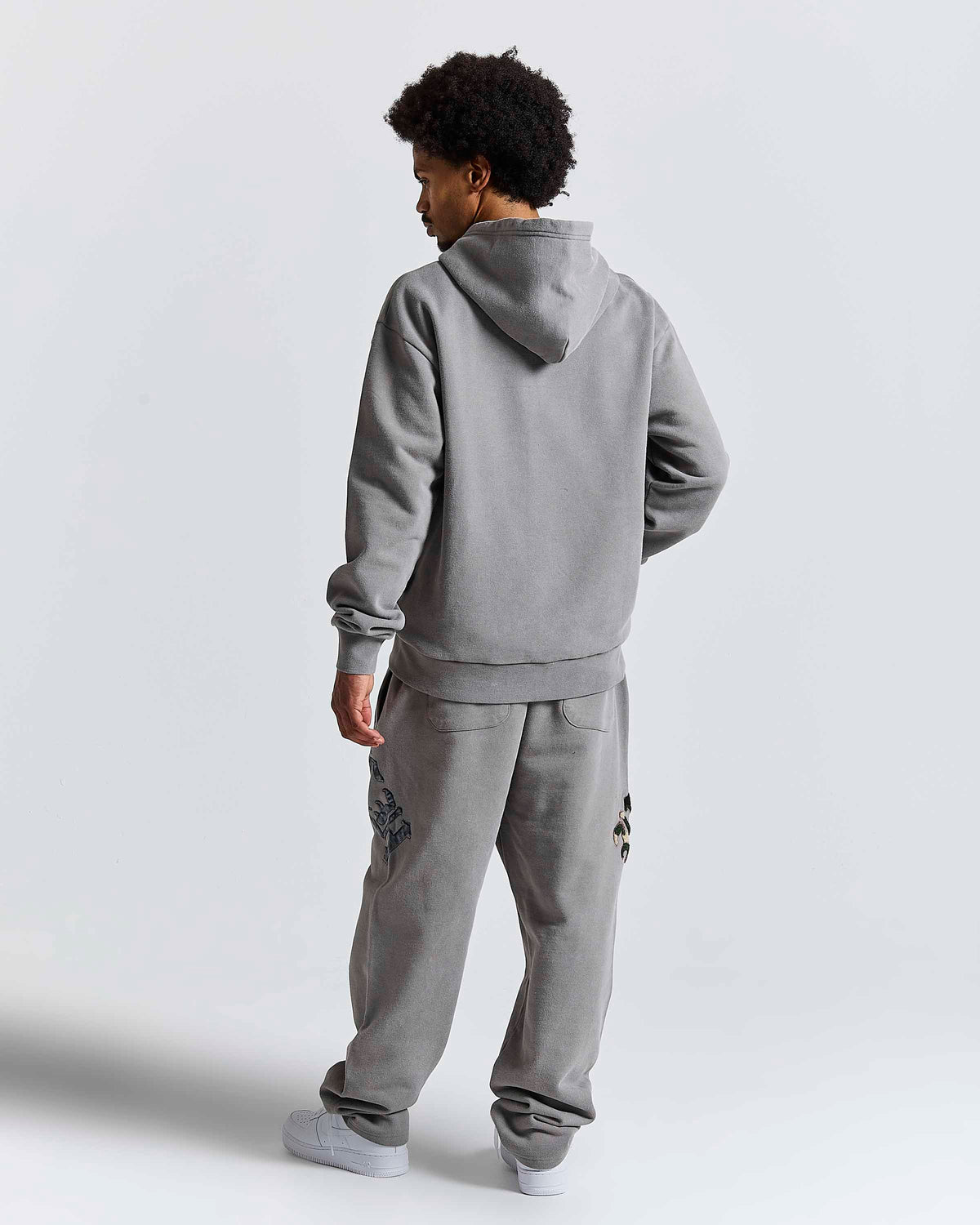 Displays a model wearing the Grey 'Hoodrich' branded men's Inkfall Full Tracksuit