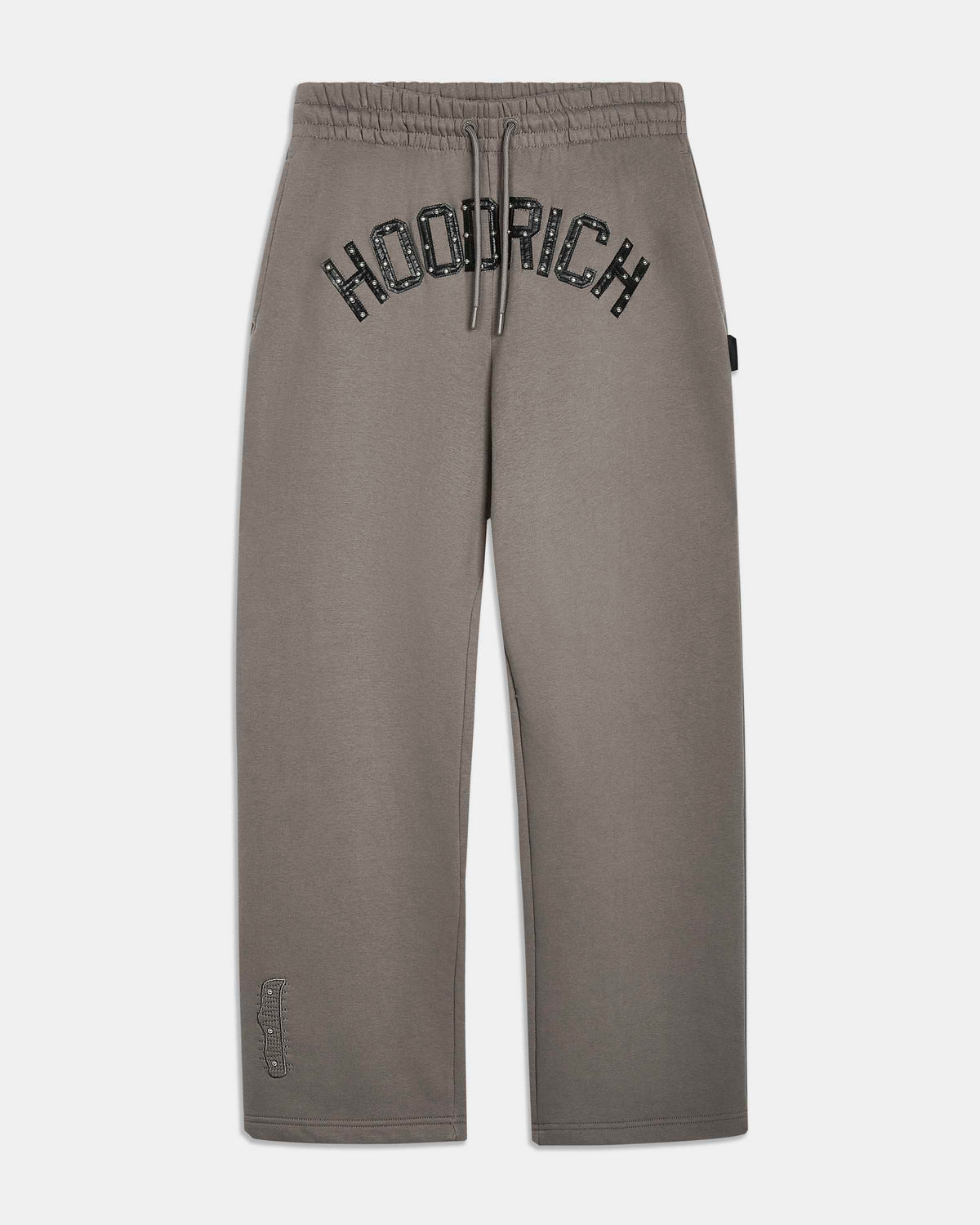 A pair of gray sweatpants featuring the brand name 'HOODRICH' printed in a black arched font across the upper thigh, displayed against a light gray background.