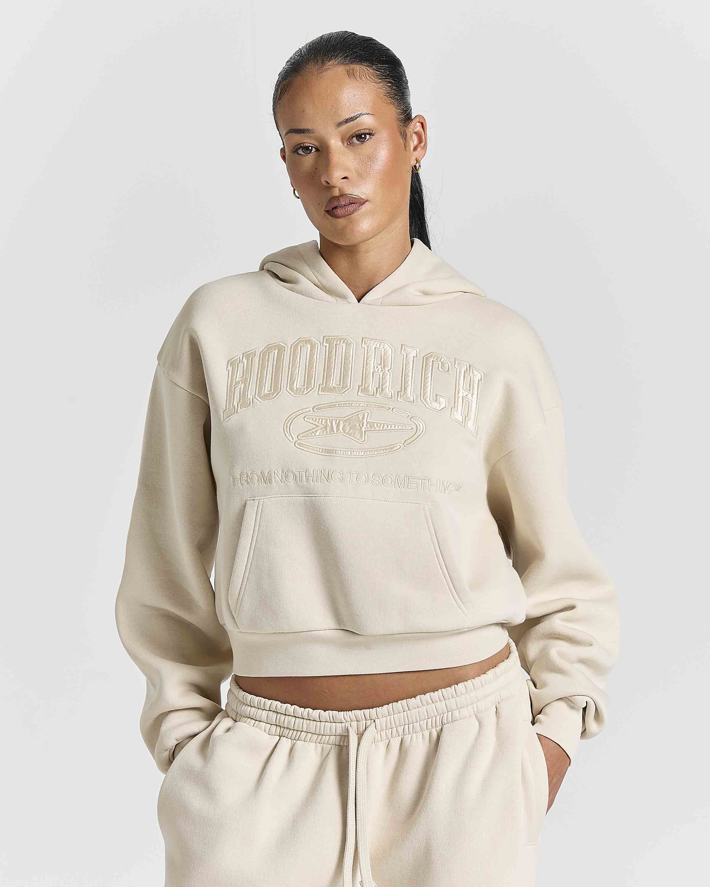 Displays a model wearing the Stone 'Hoodrich' branded women's Aegis Full Tracksuit