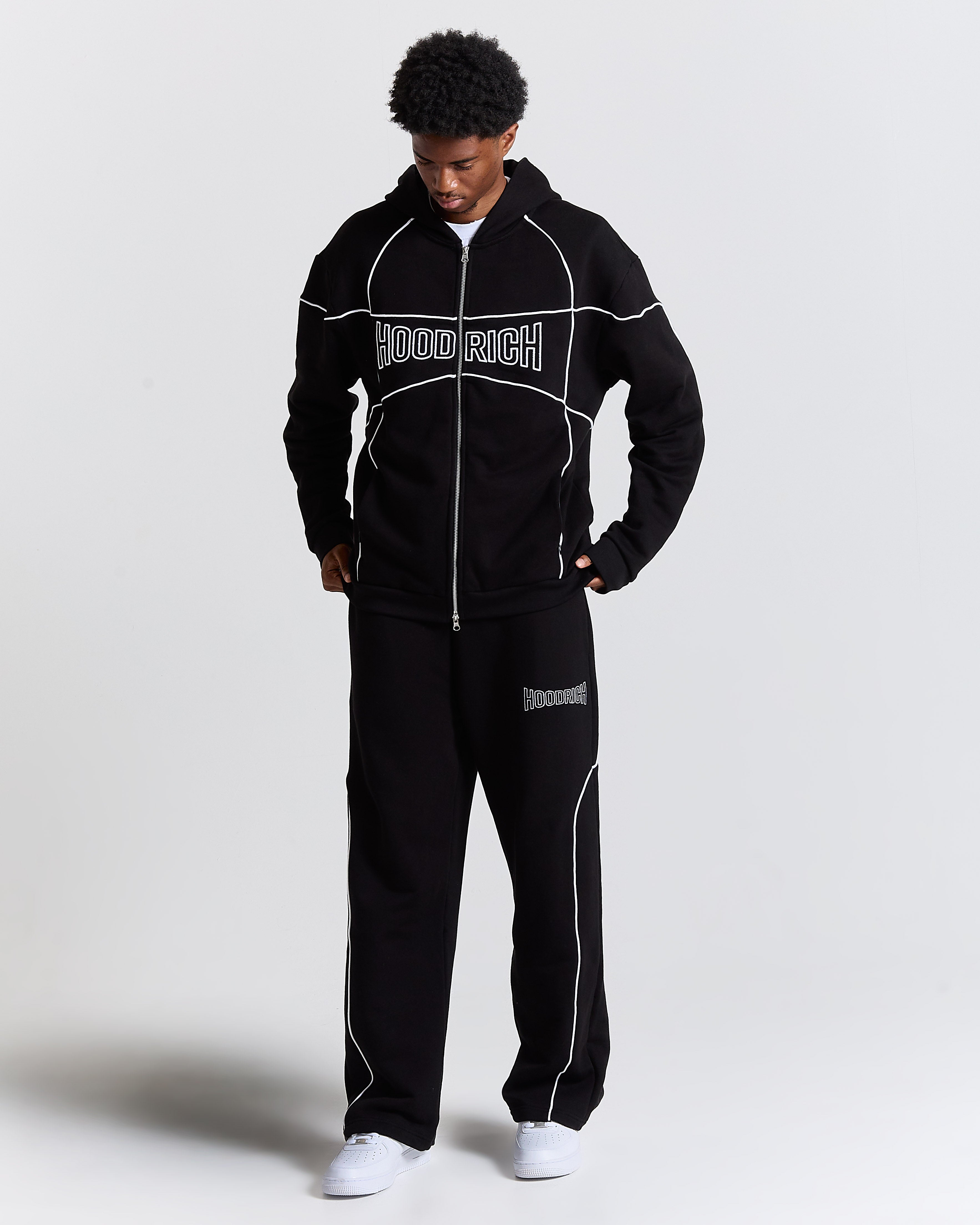 Person wearing a black tracksuit with 'HoodRich' branding on a white background
