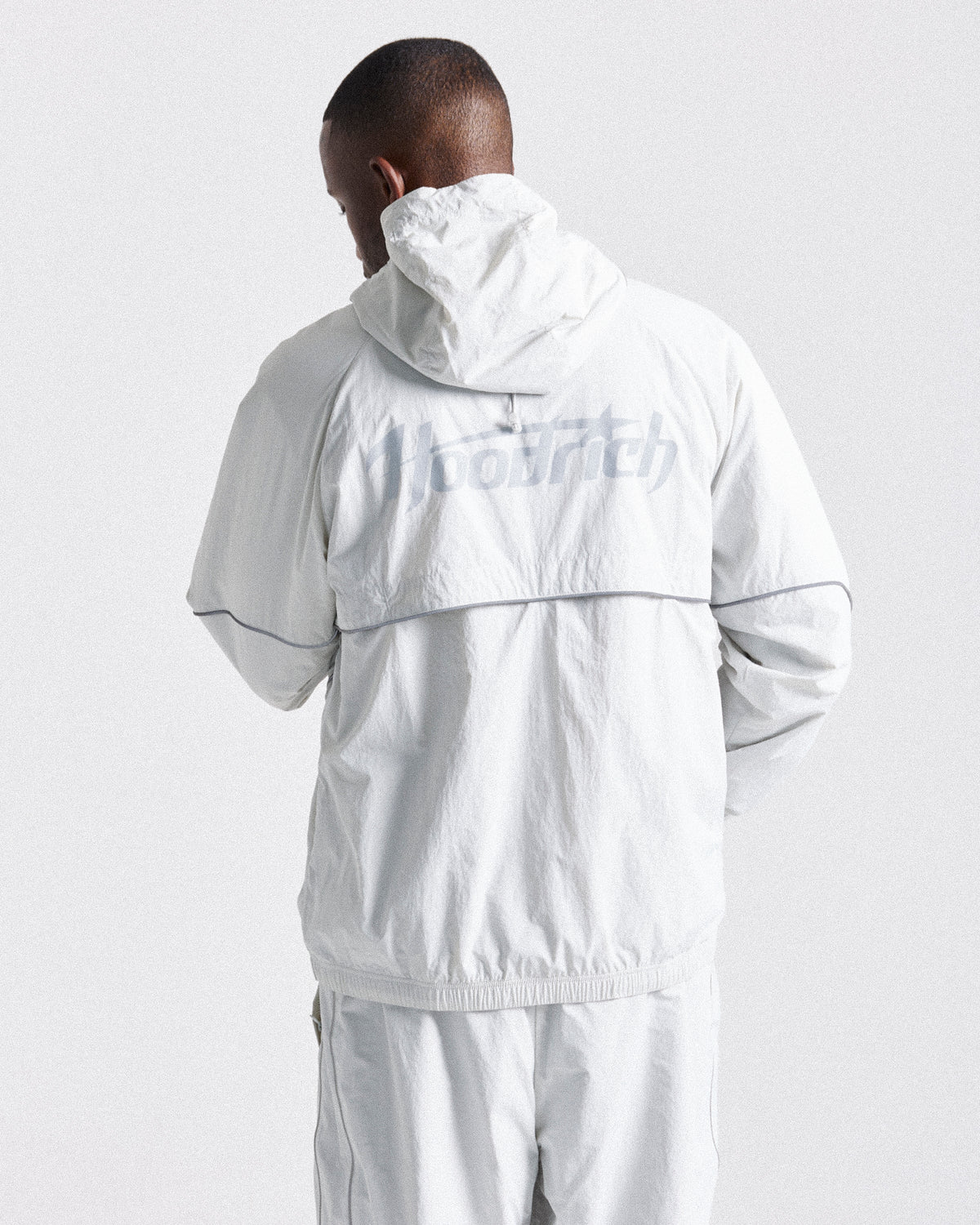 Displays a model wearing the Grey 'Hoodrich' branded men's Cypher Woven Full Tracksuit