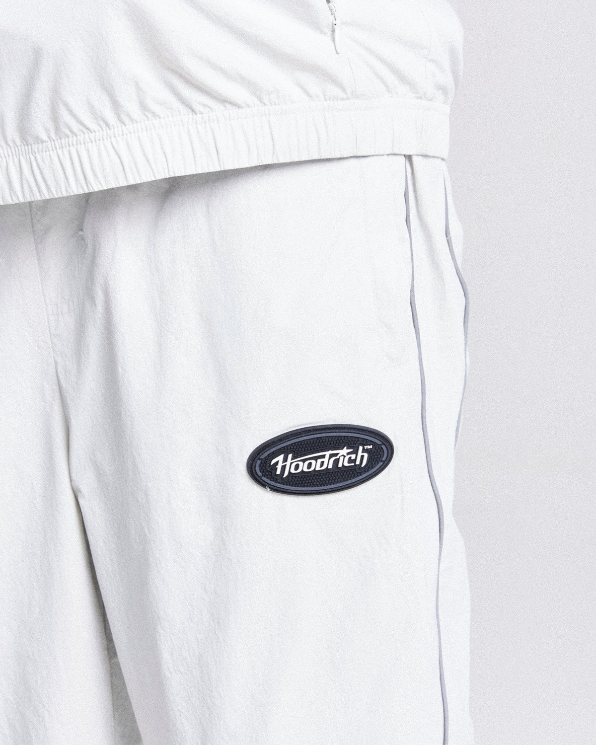 Displays a model wearing the Grey 'Hoodrich' branded men's Cypher Woven Full Tracksuit featuring the hoodrich branding