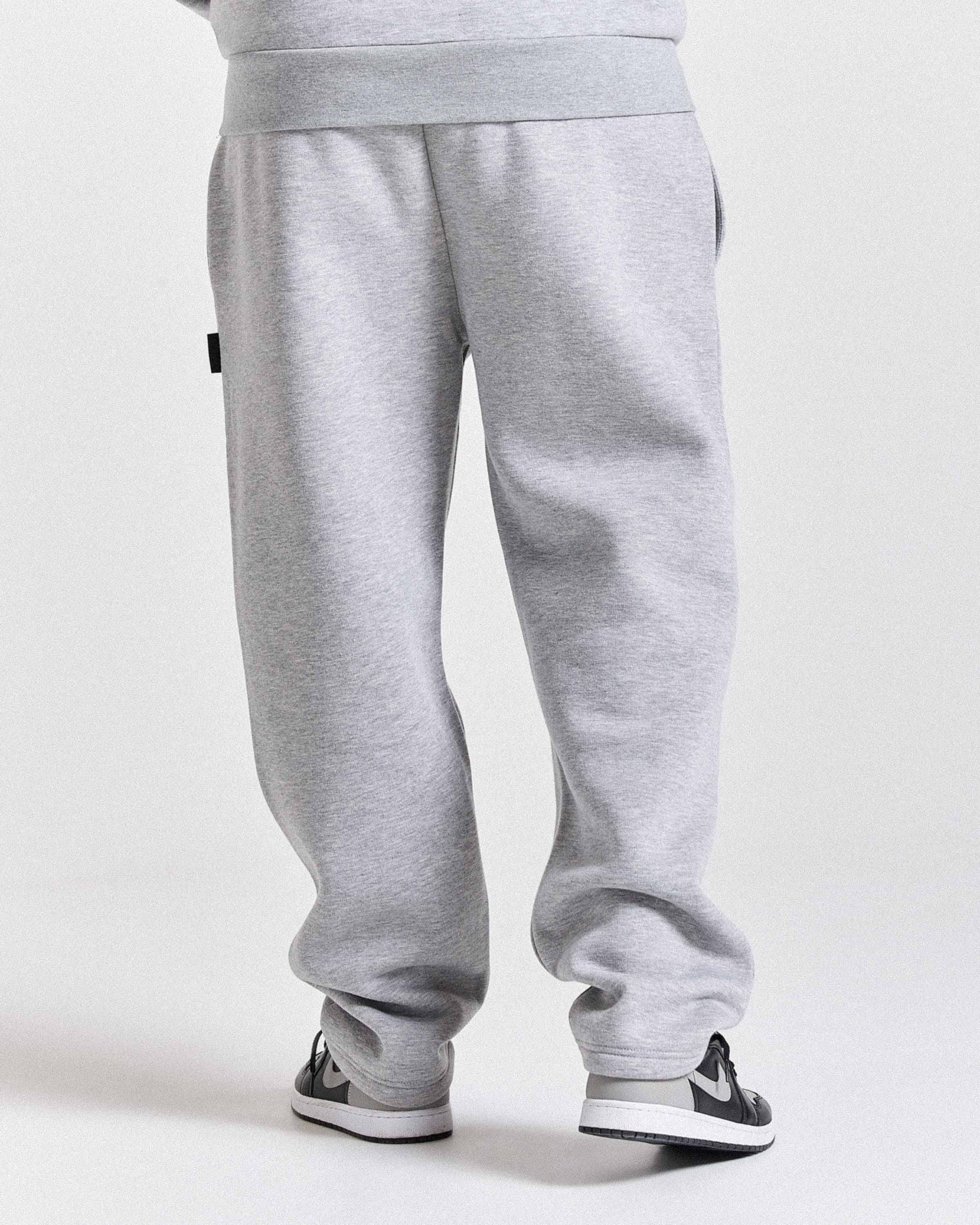 Gray sweatpants worn by a person on a white background
