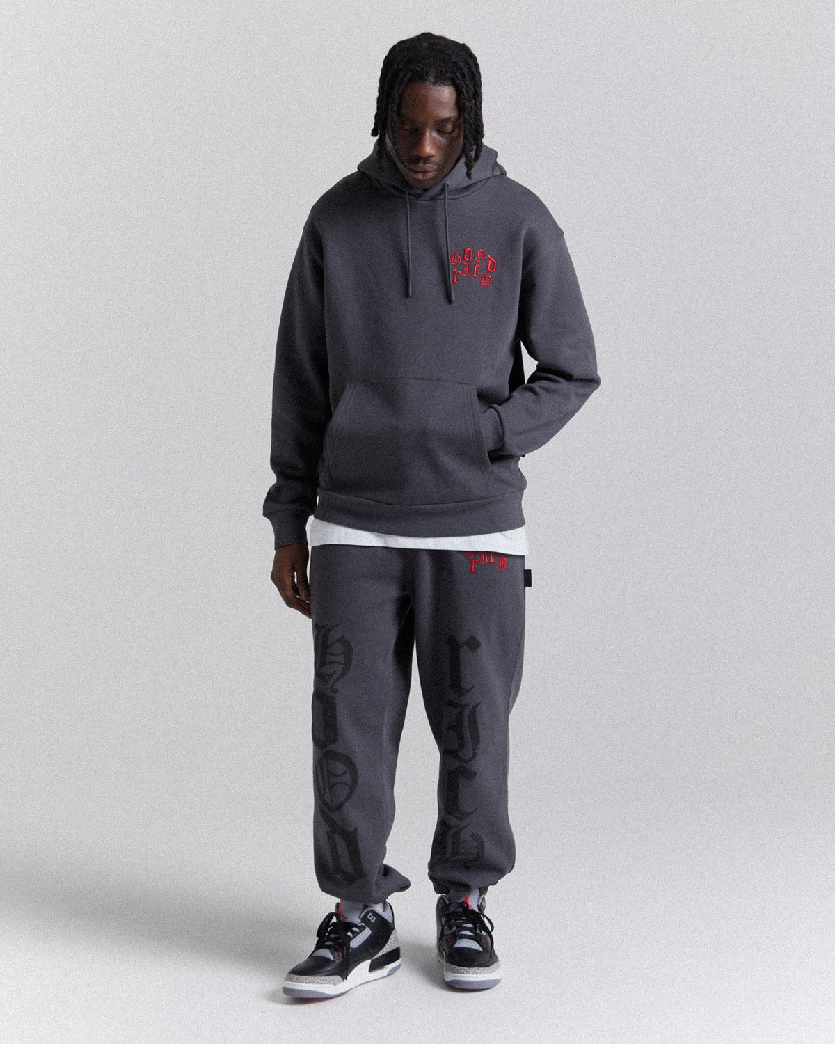 Displays a model wearing the Grey 'Hoodrich' branded men's Crown Full Tracksuit