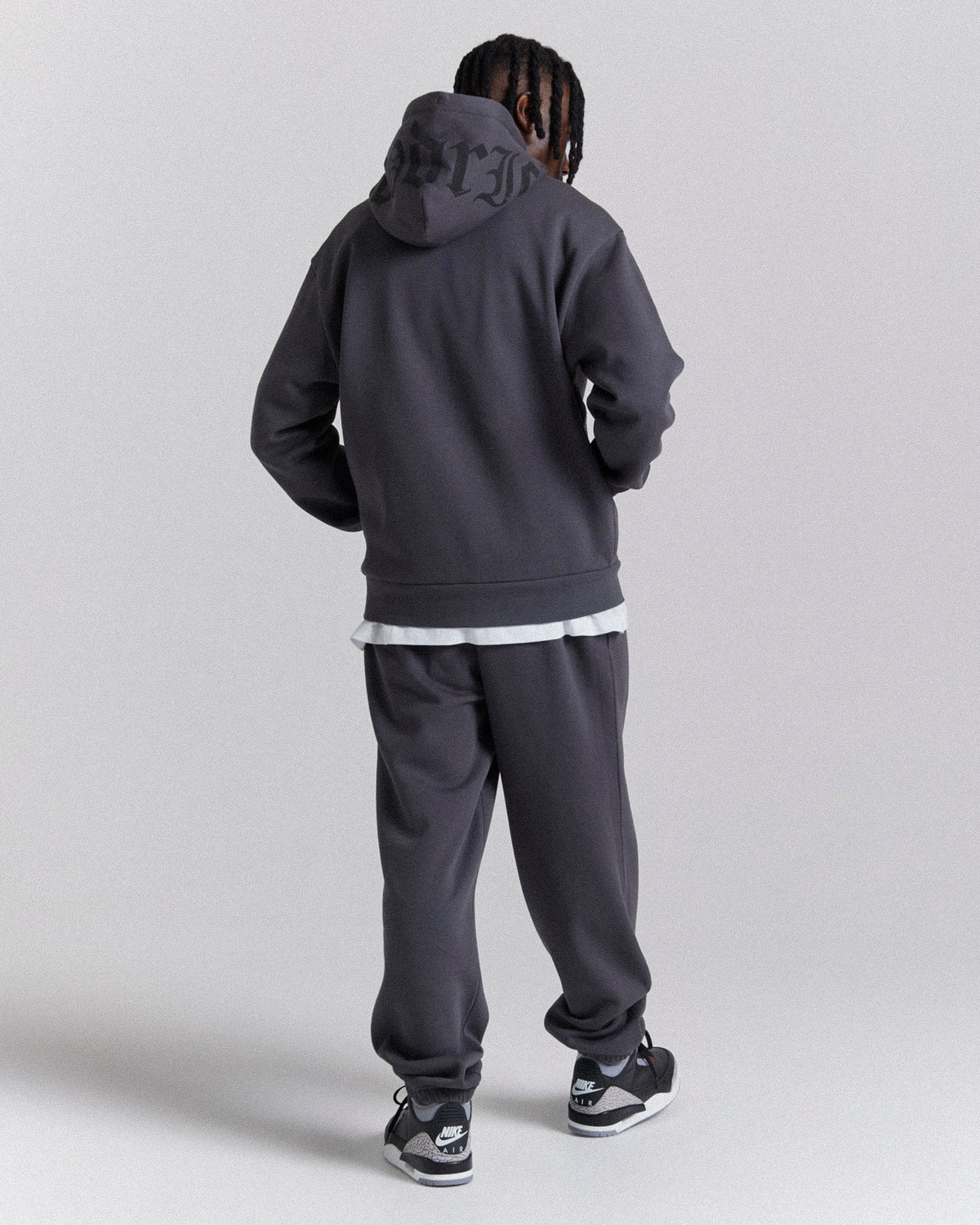 Displays a model wearing the Grey 'Hoodrich' branded men's Crown Full Tracksuit