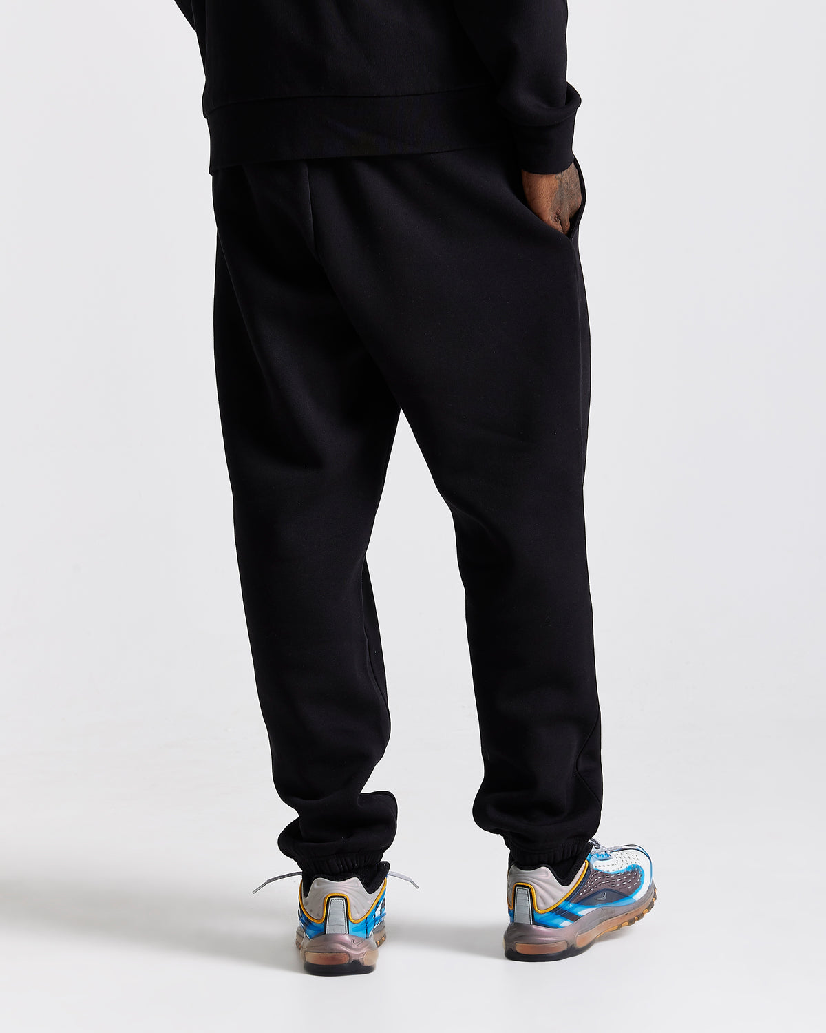 Displays a model wearing the Black 'Hoodrich' branded men's Curve Full Tracksuit