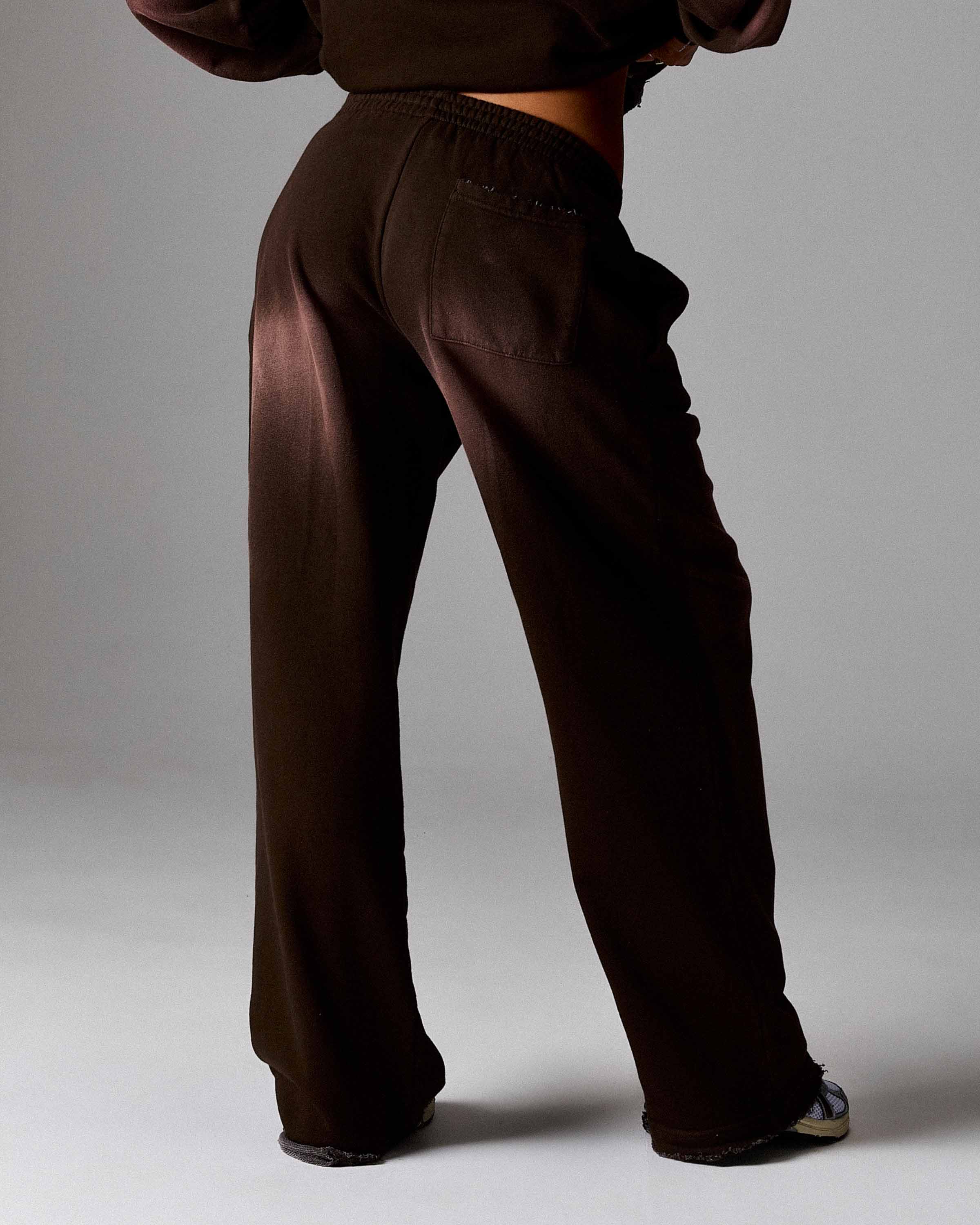 Brown pants worn by a person on a plain background