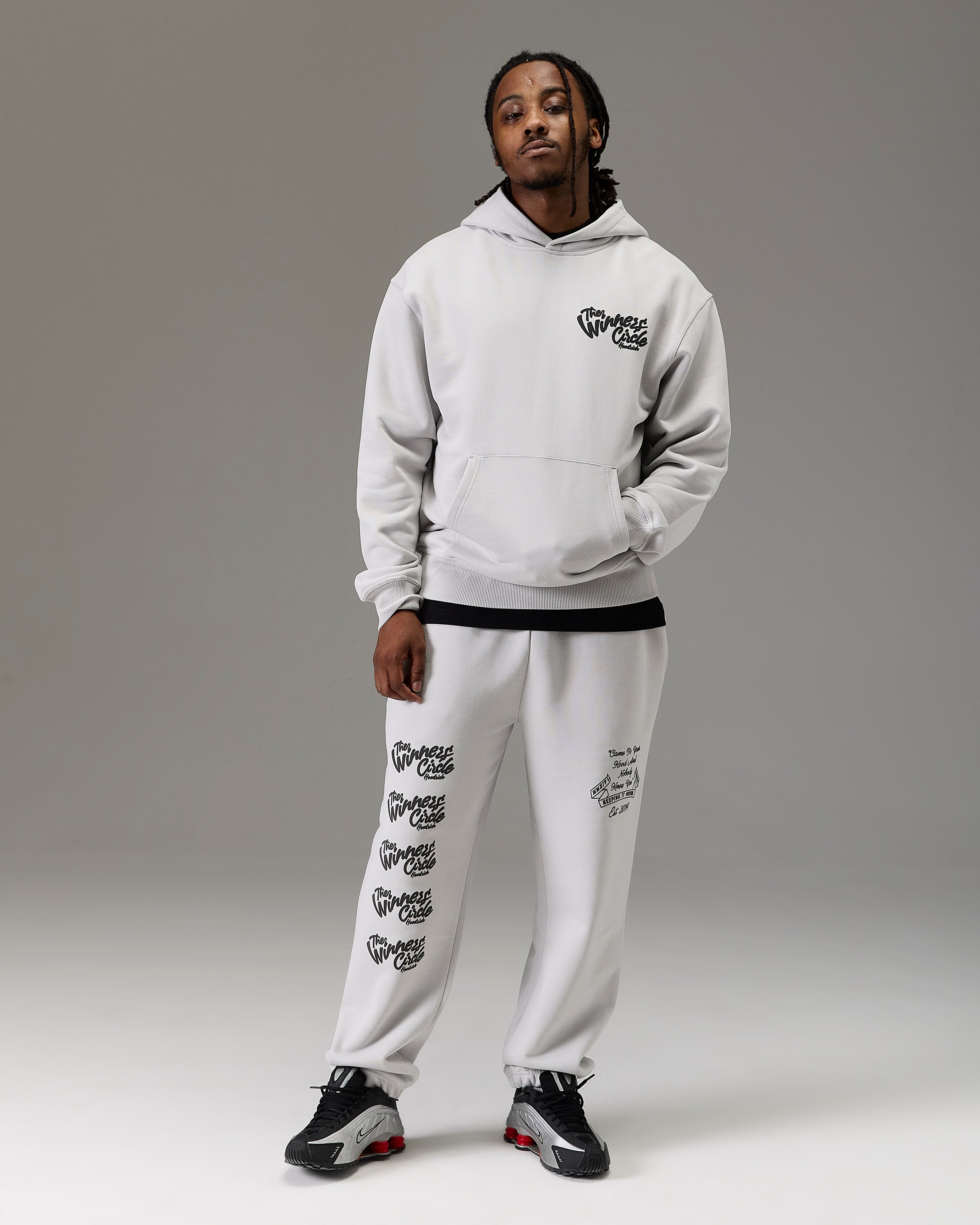 Displays a model wearing the grey 'Goodrich' branded men's winner's Circle Full Tracksuit