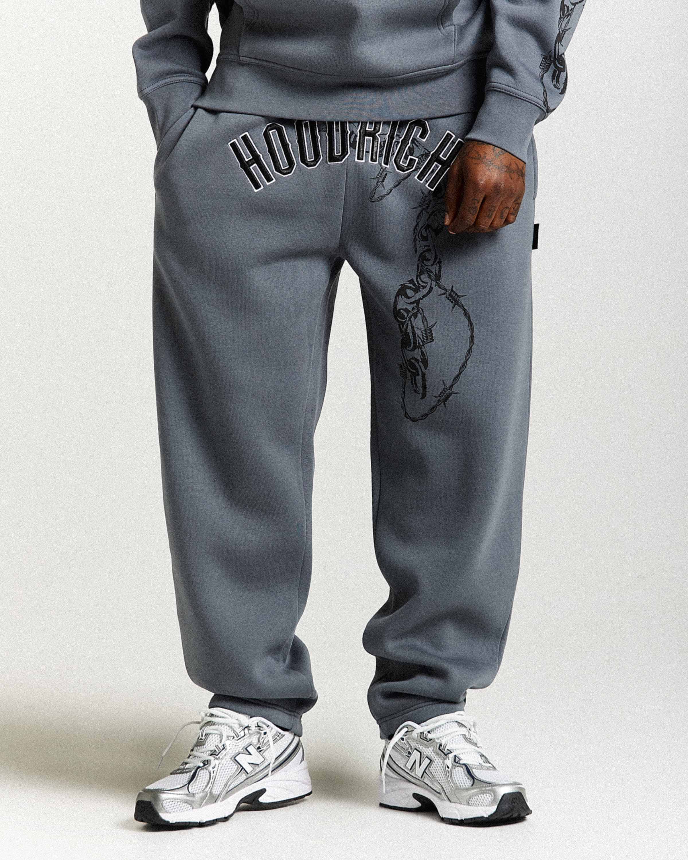 Person wearing gray sweatpants with 'HOODRICH' branding on a white background