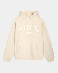 An oversized cream-colored hoodie with a tonal white 'HOODRICH' graphic and logo printed on the chest, displayed against a light gray background.