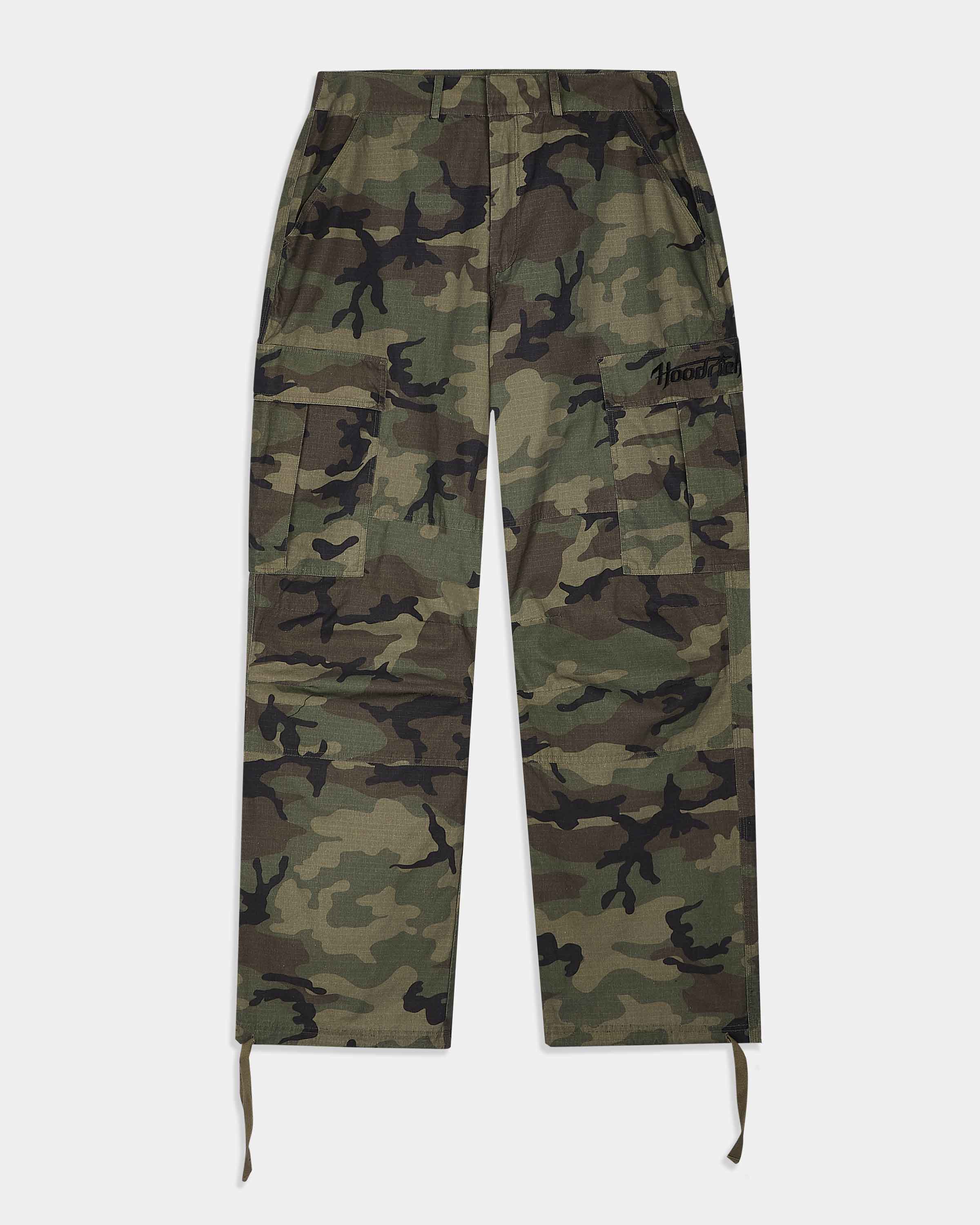 A pair of camouflage cargo pants with a green, brown, and black camo pattern, featuring a drawstring waist and hem, and a small black embroidered logo on the right thigh.
