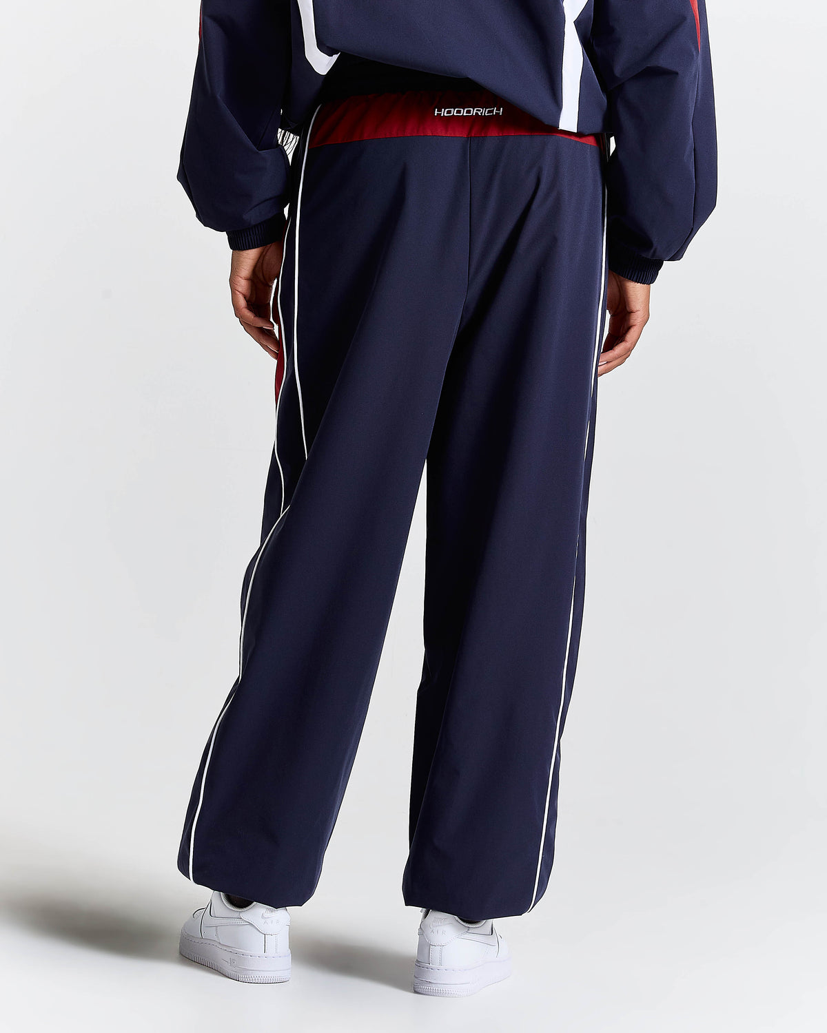 Navy tracksuit with white stripes on a light gray background