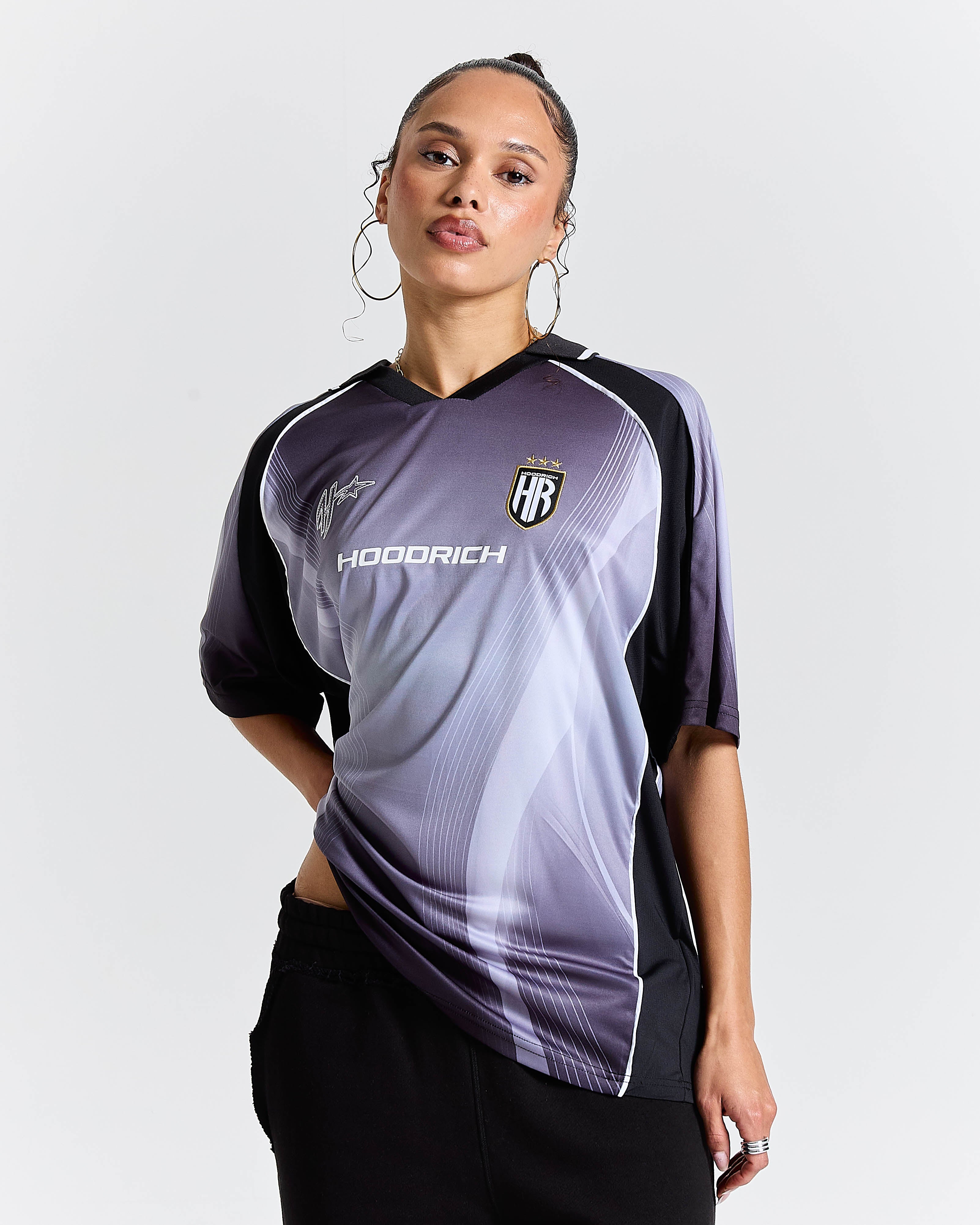 Person wearing a black and gray sports jersey with 'Hoodrich' branding on a light gray background