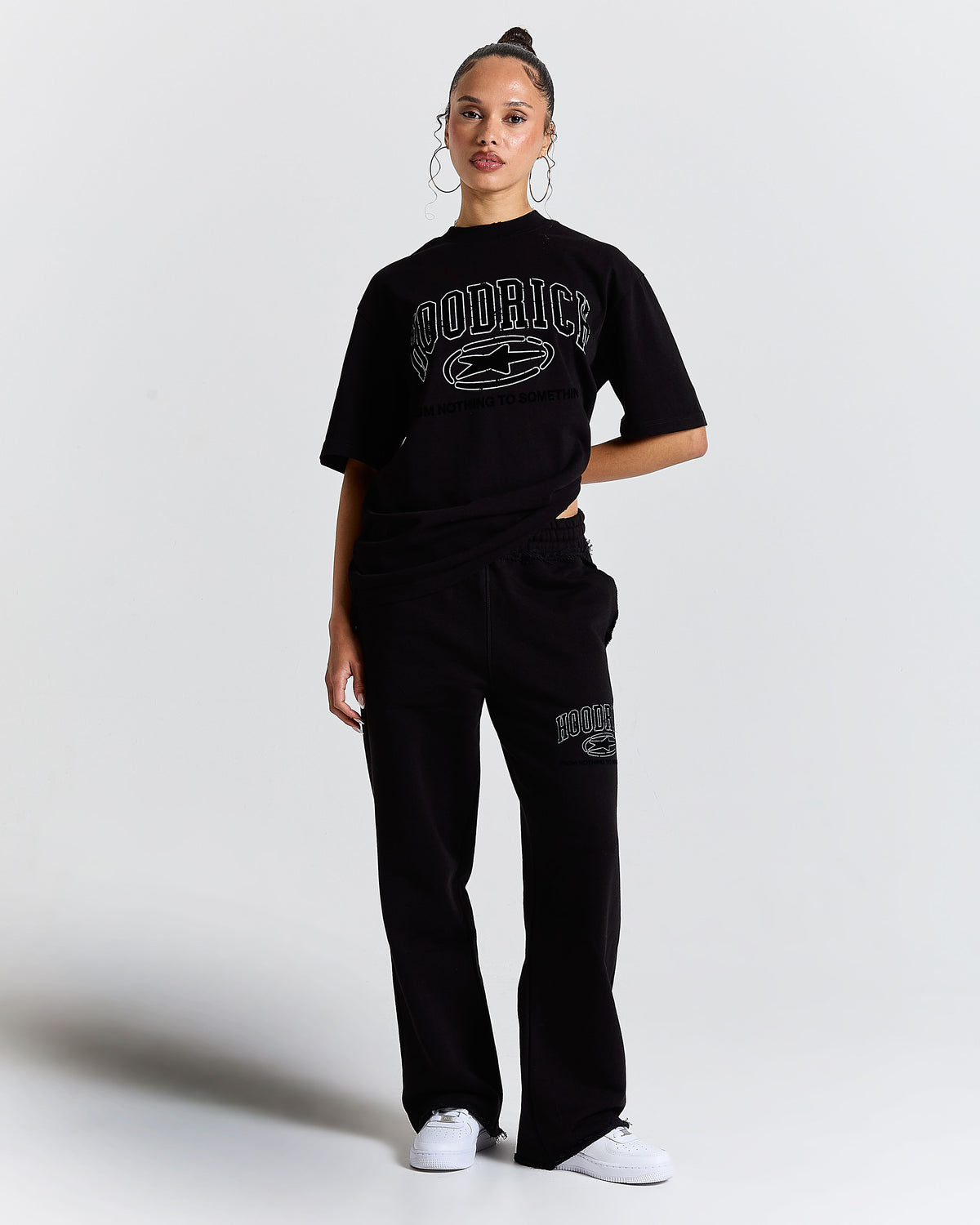 Front view of a female model wearing a regular-fit black Hoodrich t-shirt.
