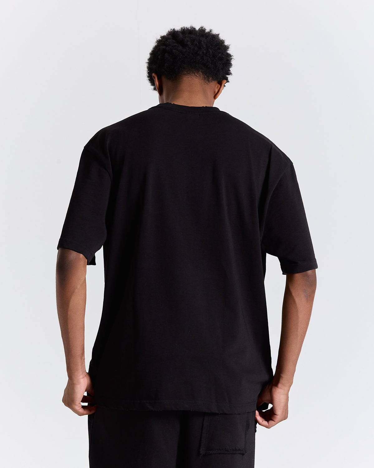 Person wearing a black t-shirt against a plain background