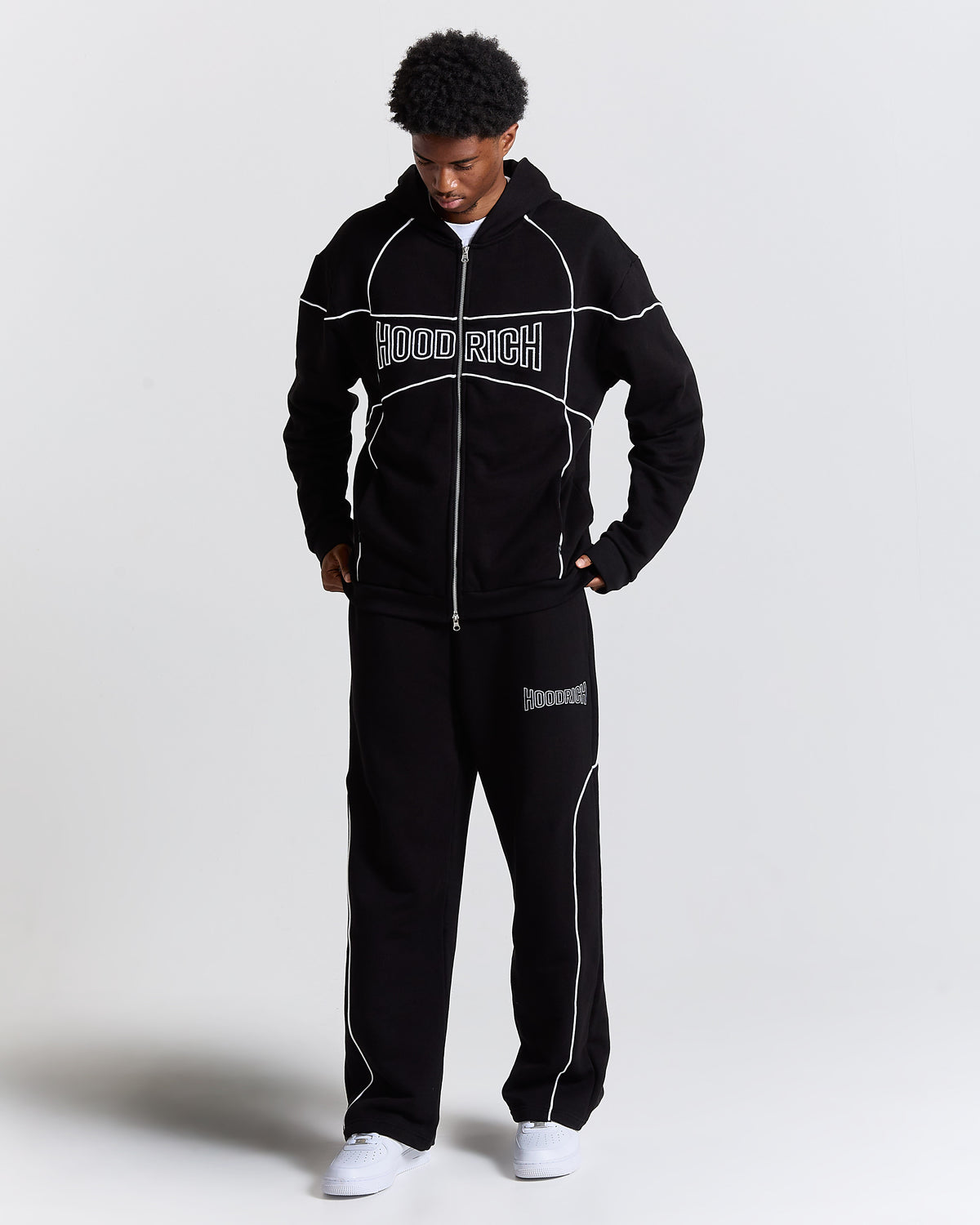 Person wearing a black tracksuit with 'HoodRich' branding on a white background