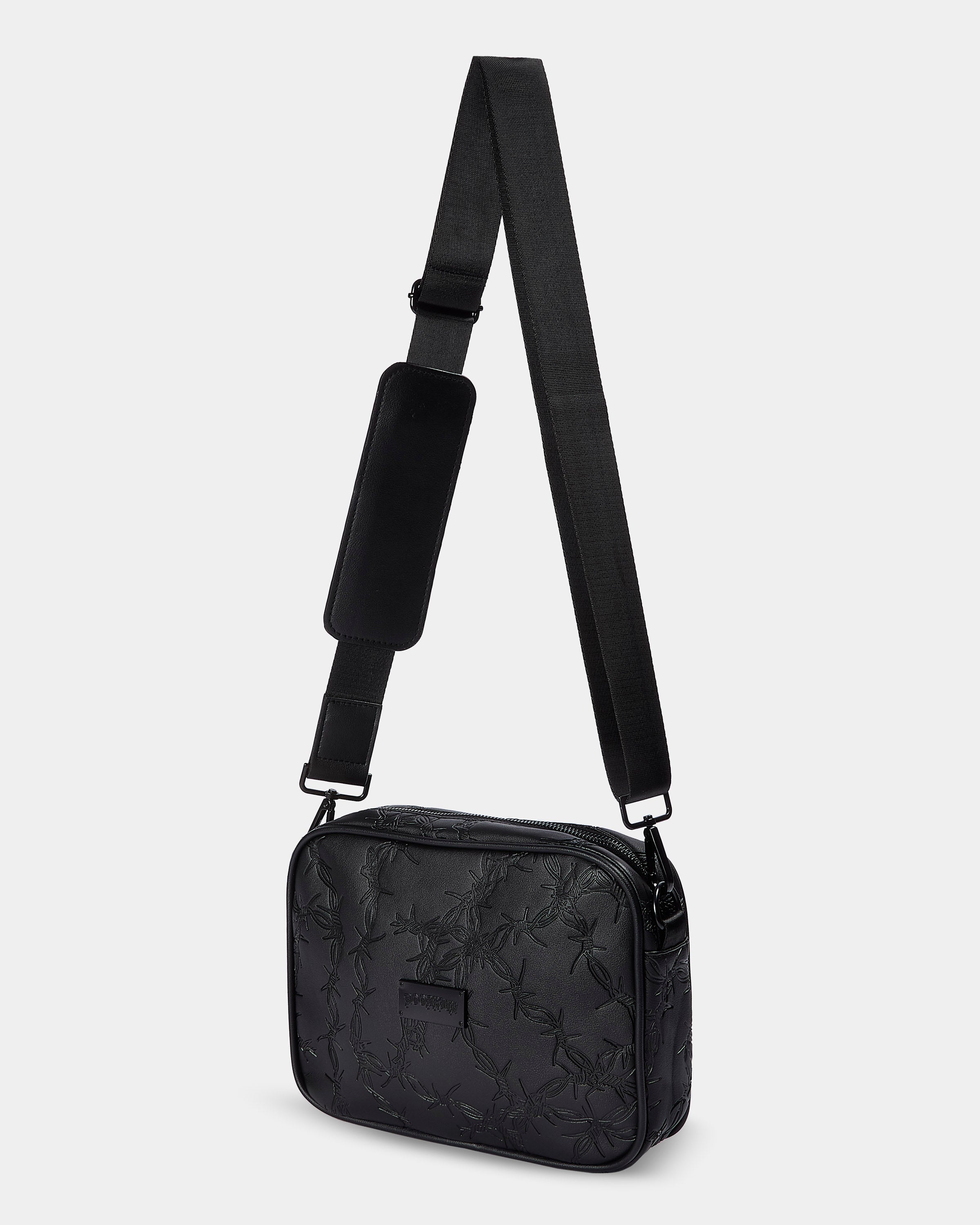 Black crossbody bag with floral pattern on a light gray background