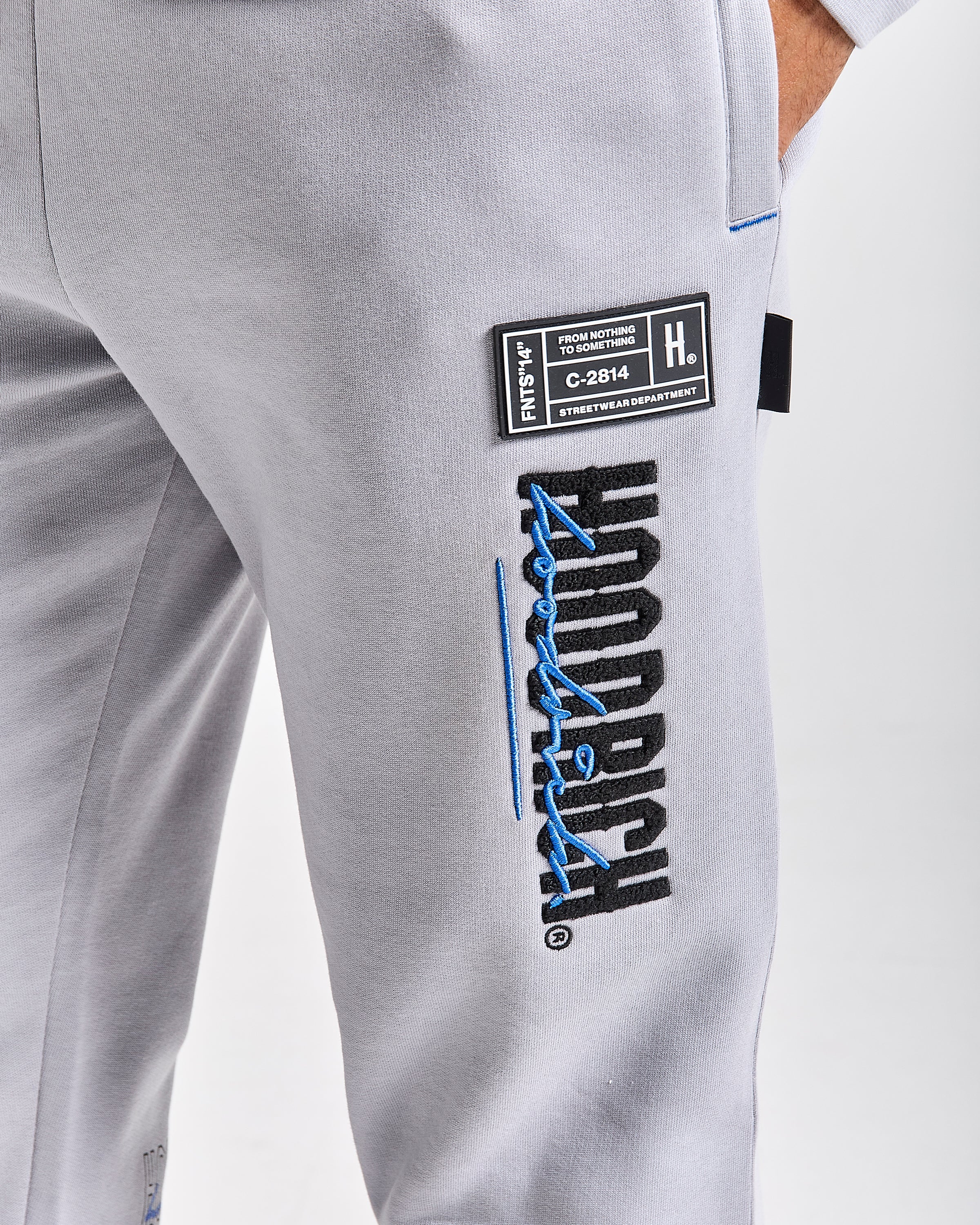 Displays a model wearing the Grey 'Hoodrich' branded men's blend Full Tracksuit 
