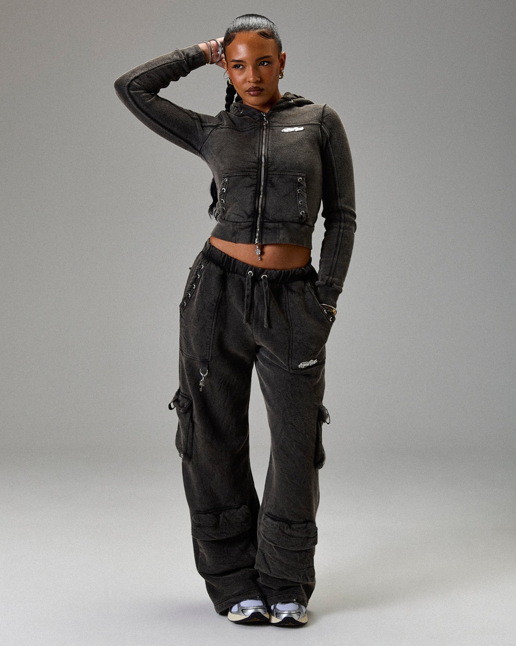 Person wearing a black outfit with a jacket and pants on a gray background