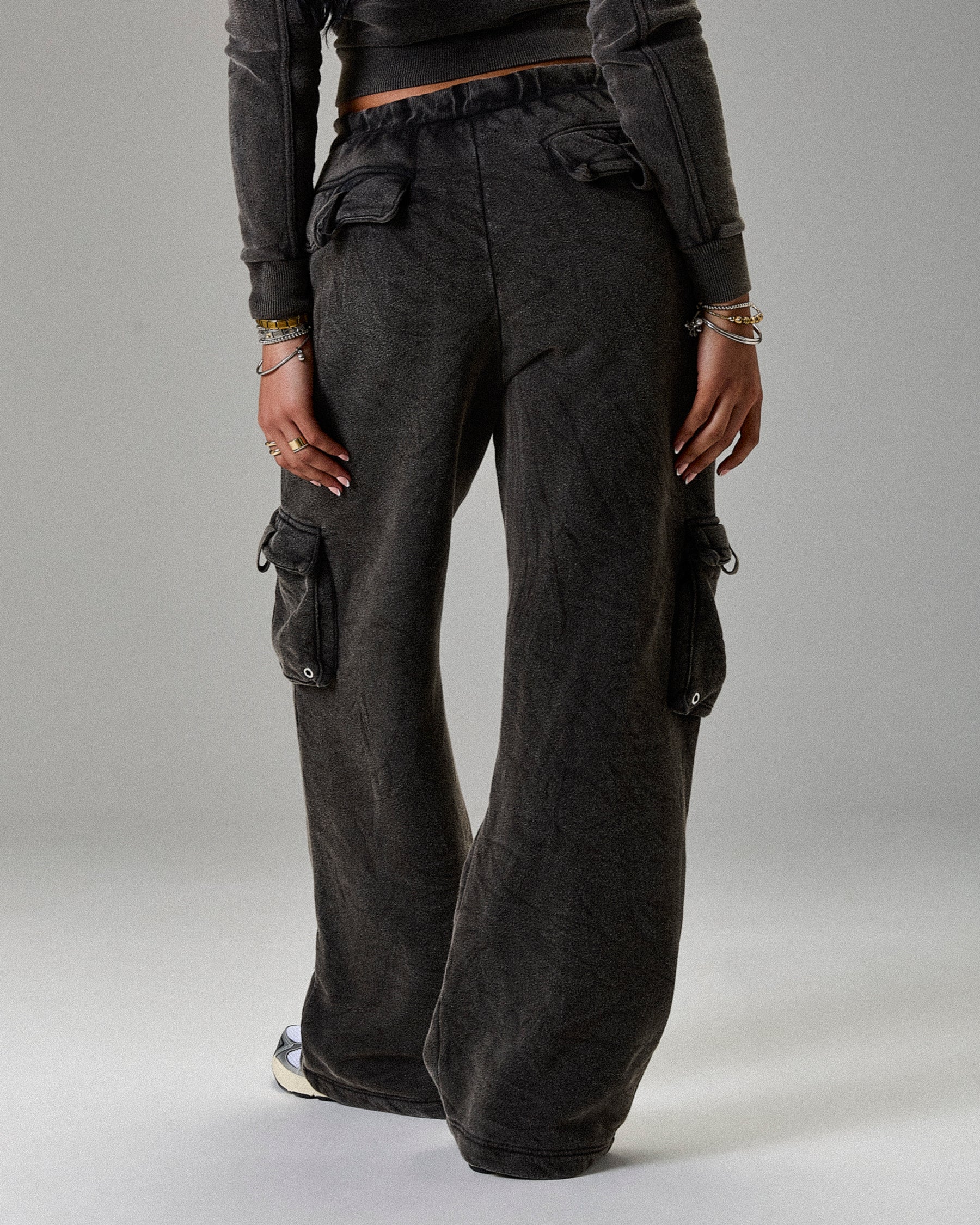 Dark gray cargo pants worn by a person on a light gray background