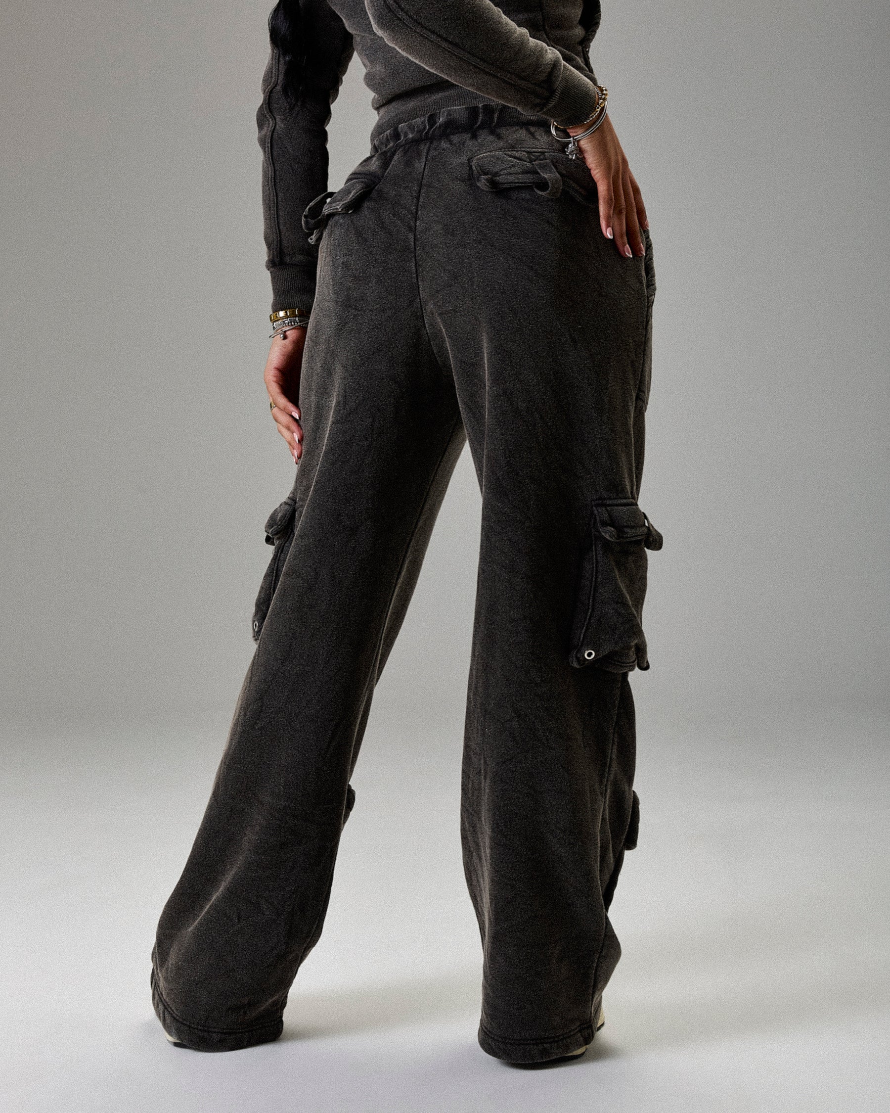 Dark gray cargo pants worn by a person on a plain background