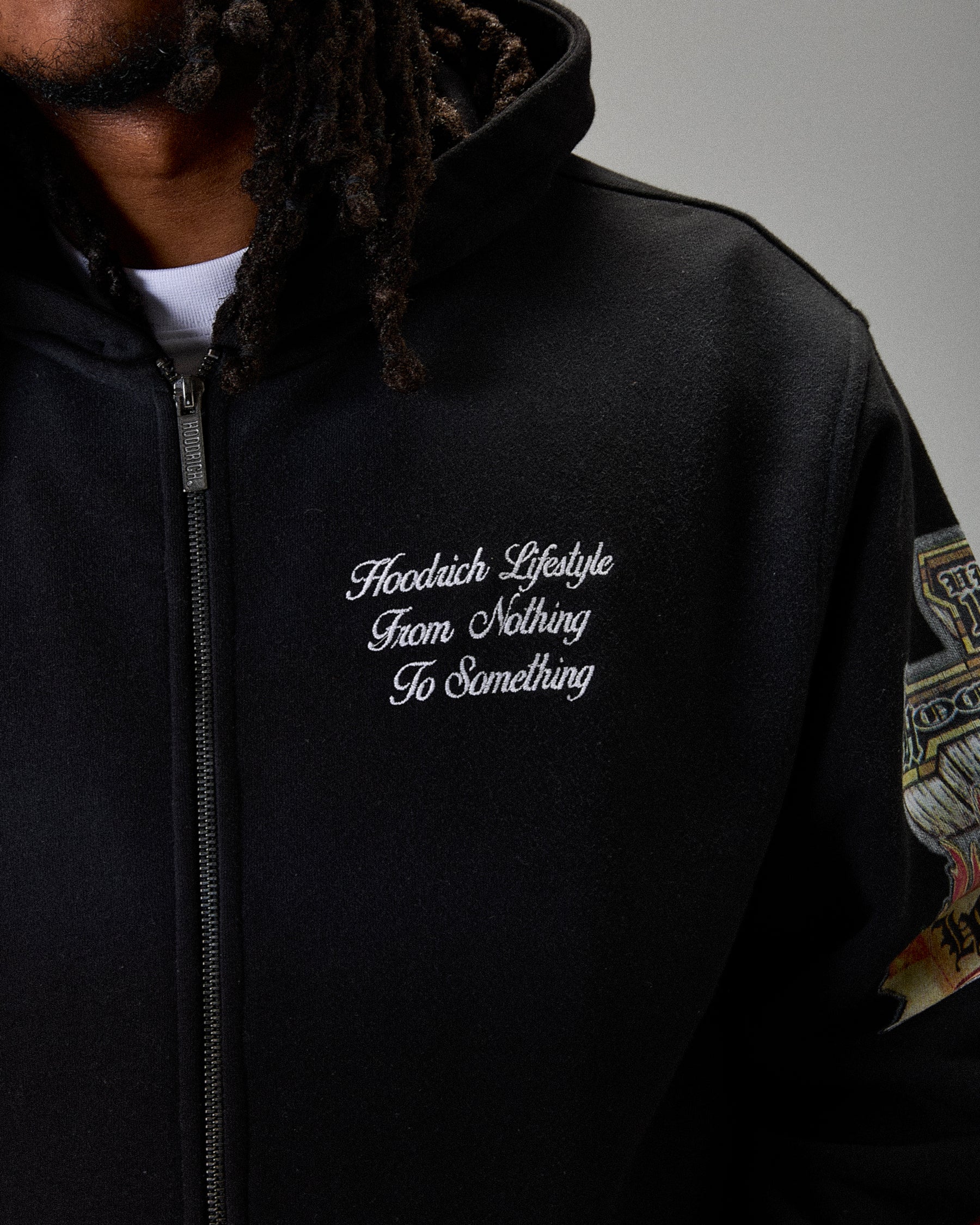 Black hoodie with embroidered text on a gray background