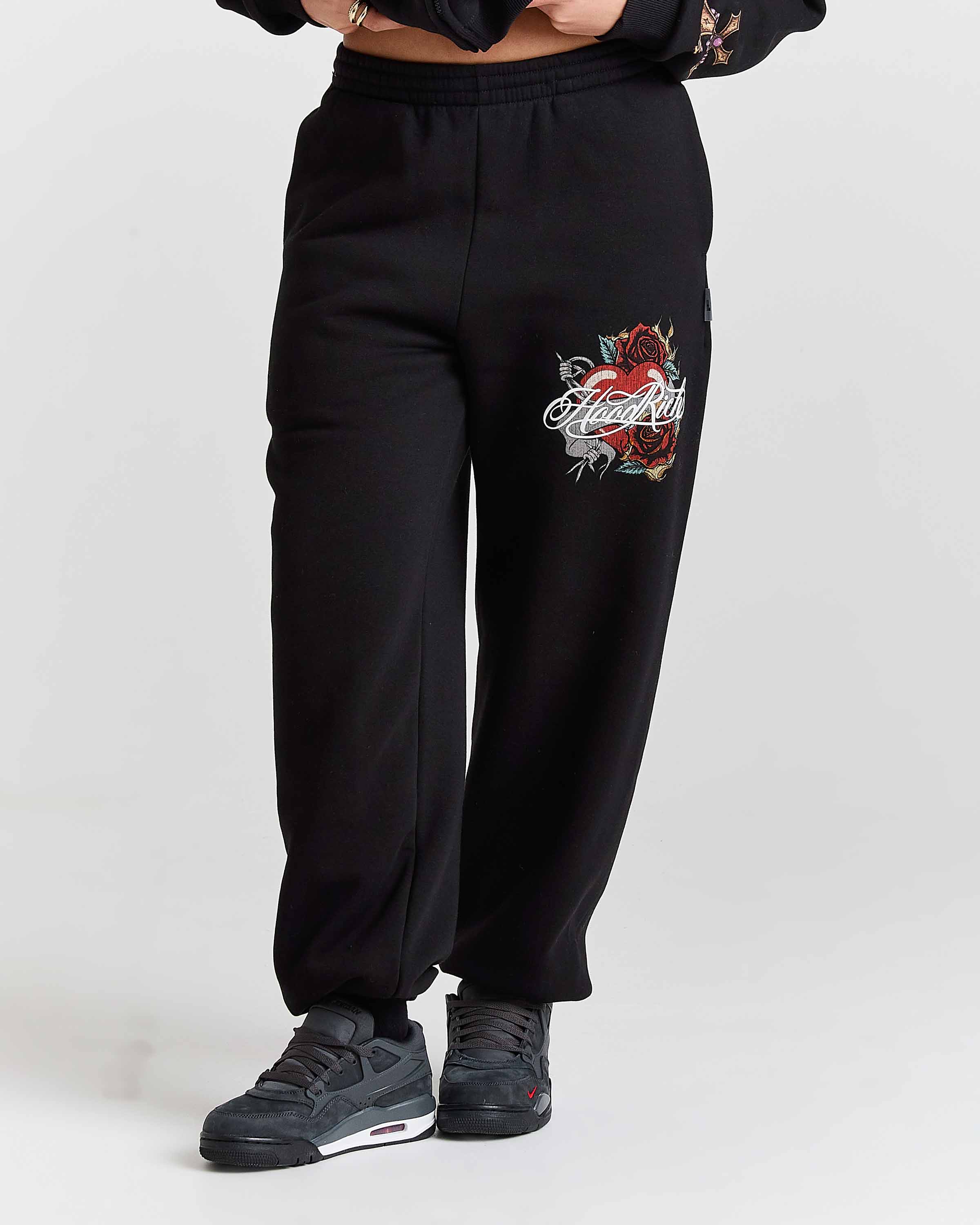 Black sweatpants with a rose design on a white background