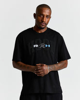 Man wearing a black t-shirt with a logo on a plain background
