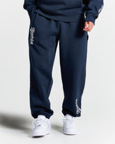 Navy tracksuit with white branding on a light gray background