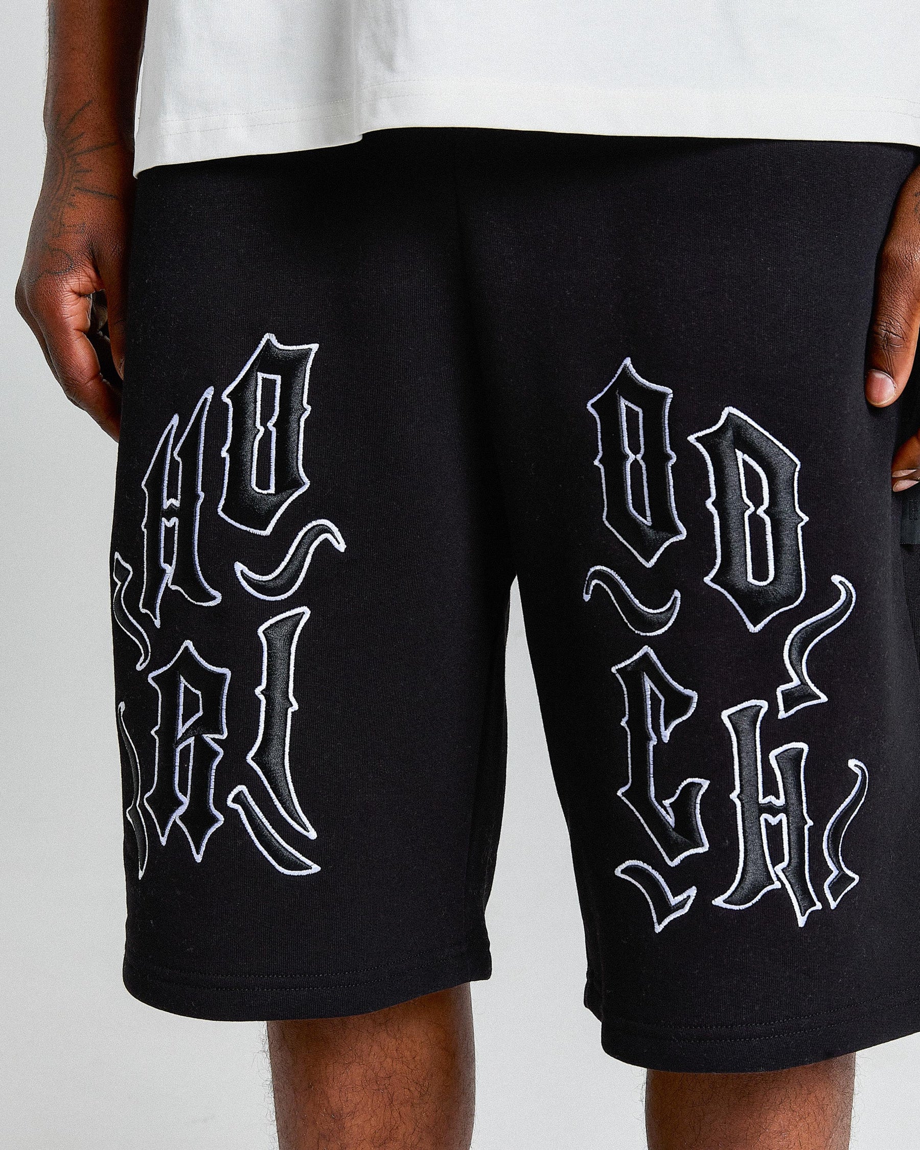 Black shorts with white text design on a plain background