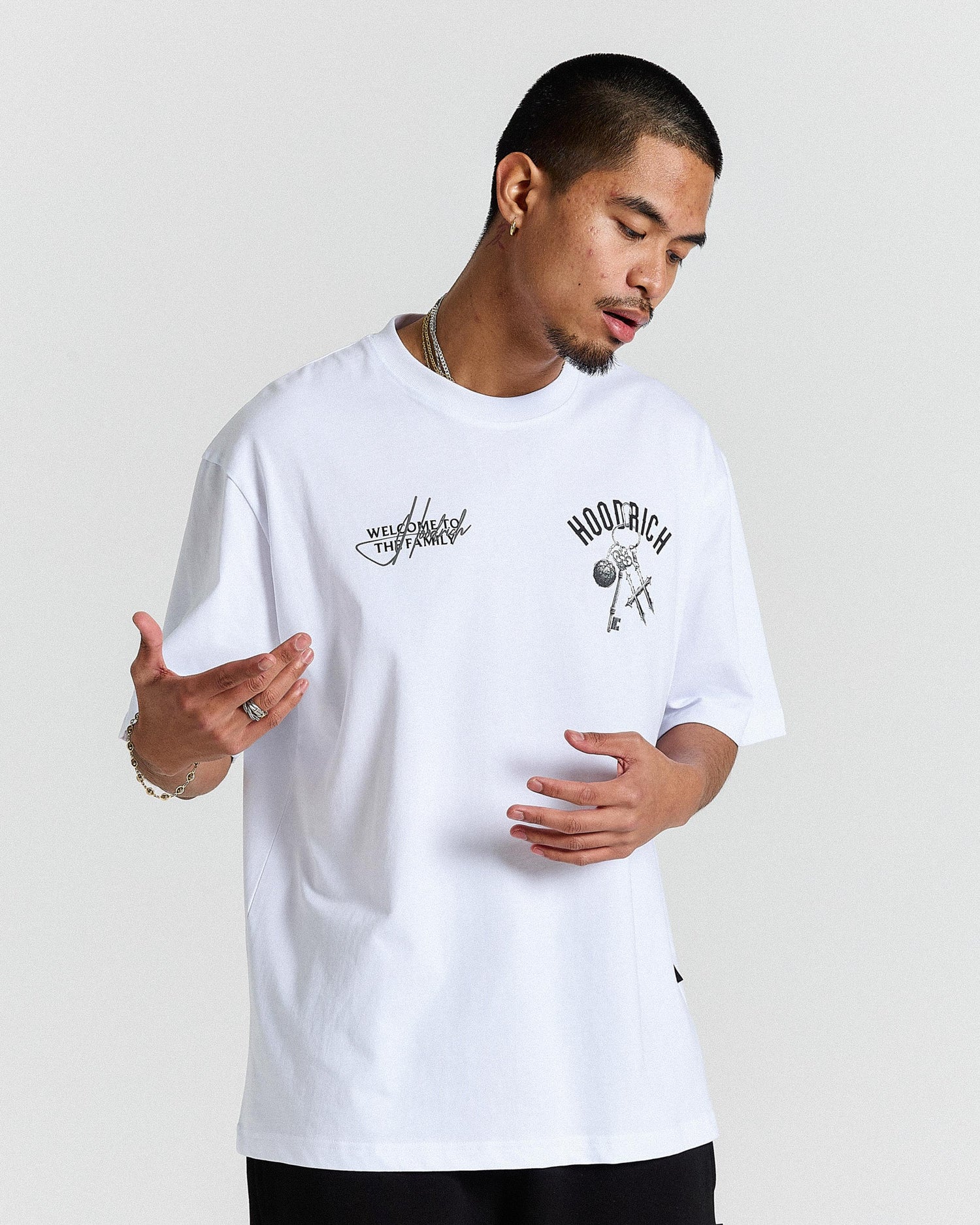 Man wearing a white t-shirt with graphics and text on a plain background