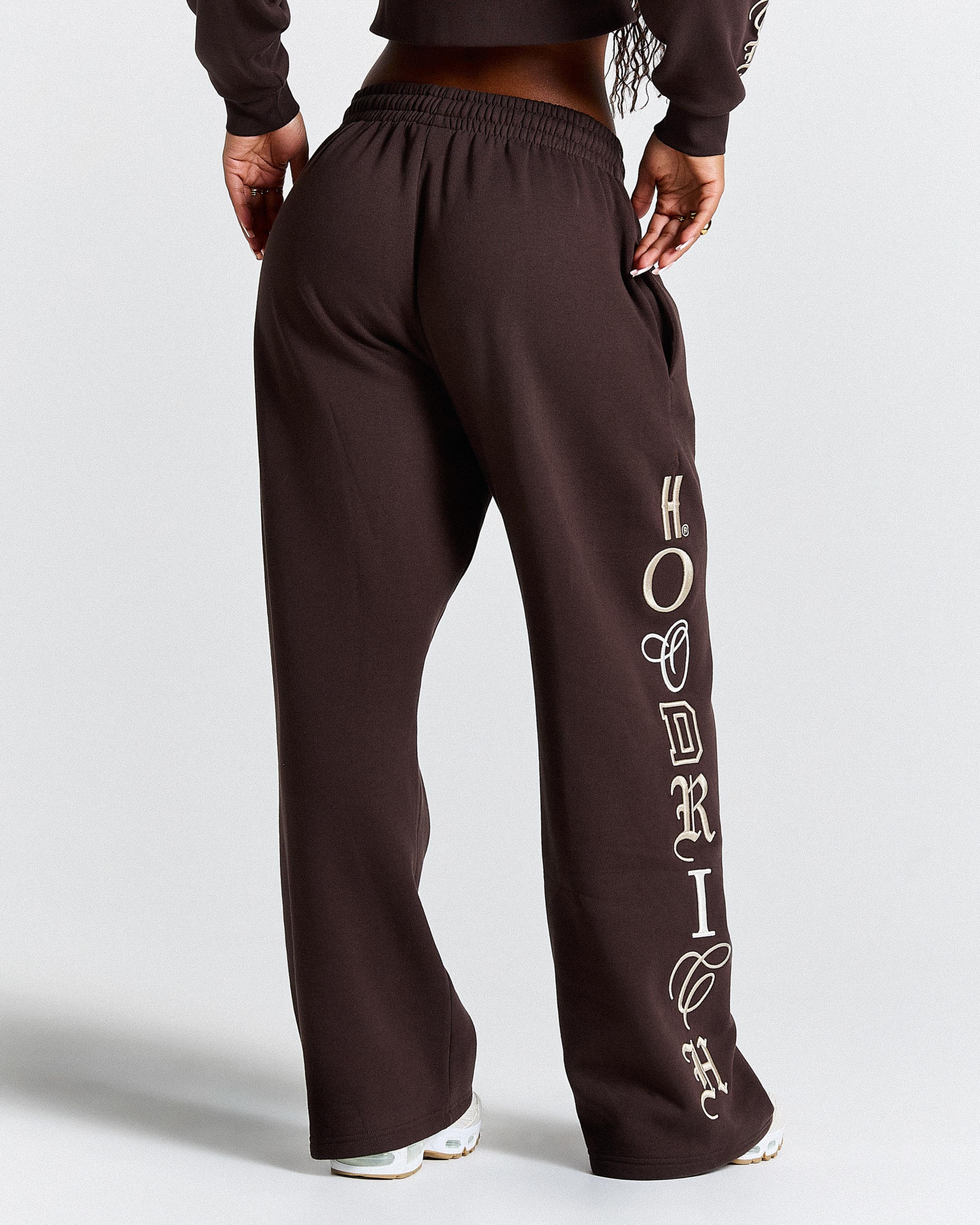 Brown sweatpants with 'Hoodrich' branding on a white background