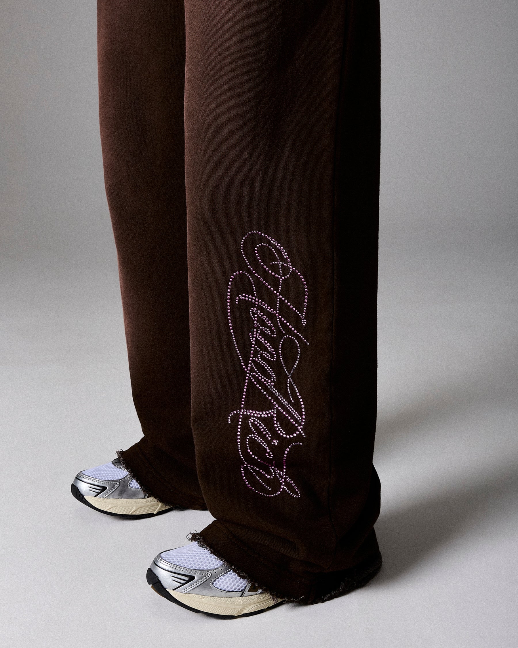 Brown pants with white embroidery on a gray background