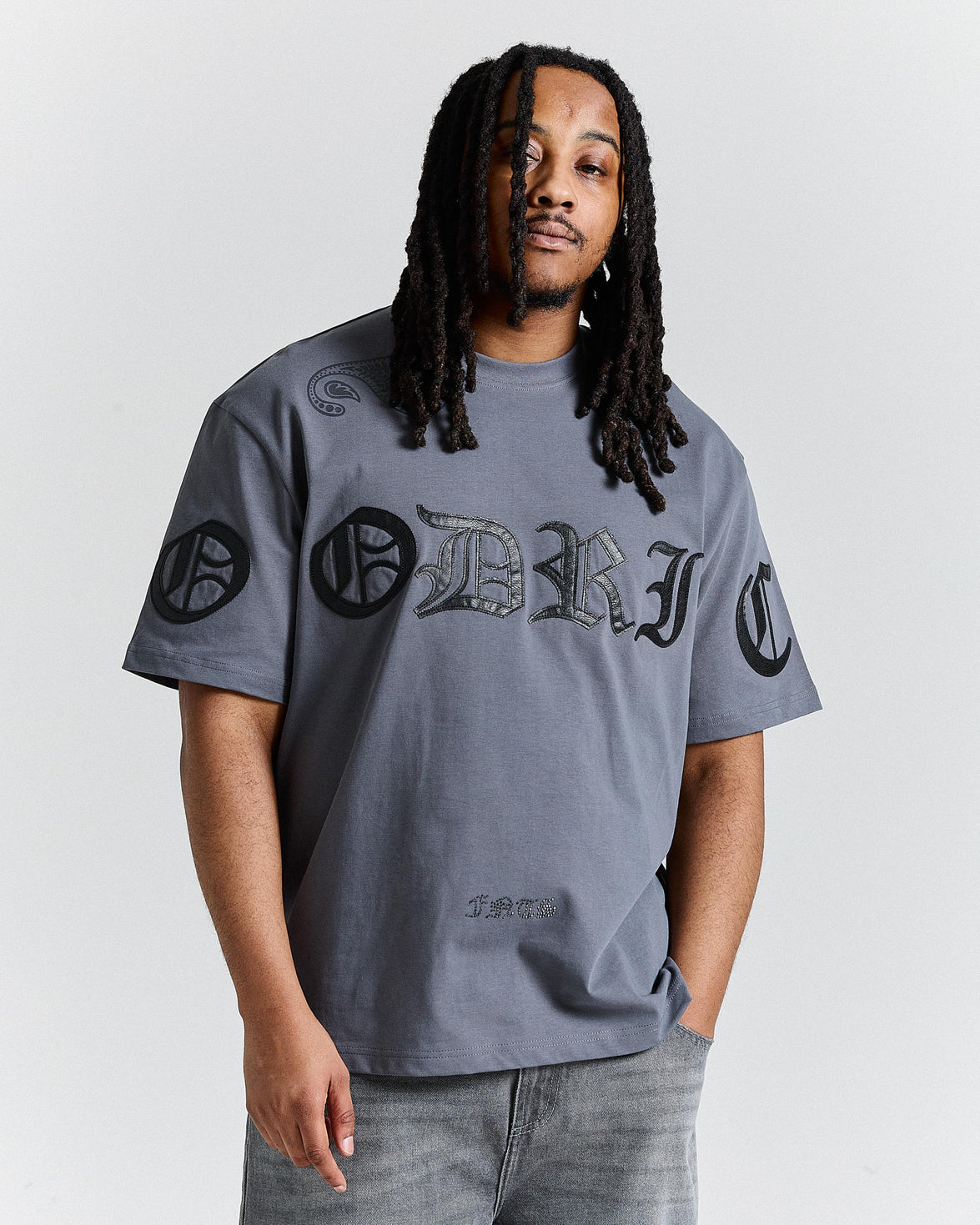 Man wearing a gray t-shirt with black and green graphics on a white background