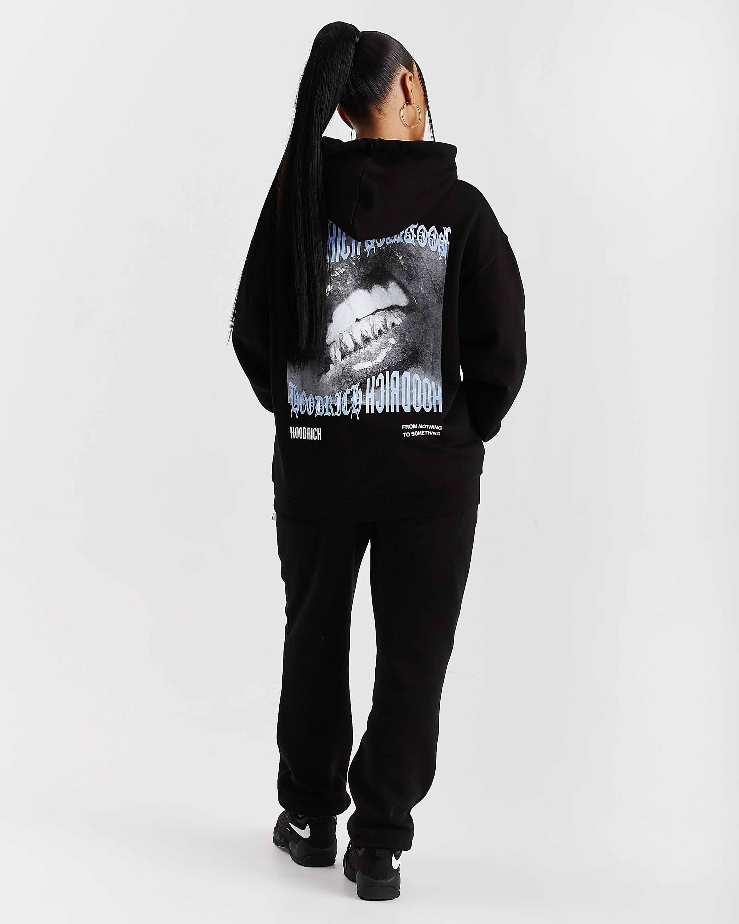 Person wearing a black hoodie with graphic design on the back against a white background