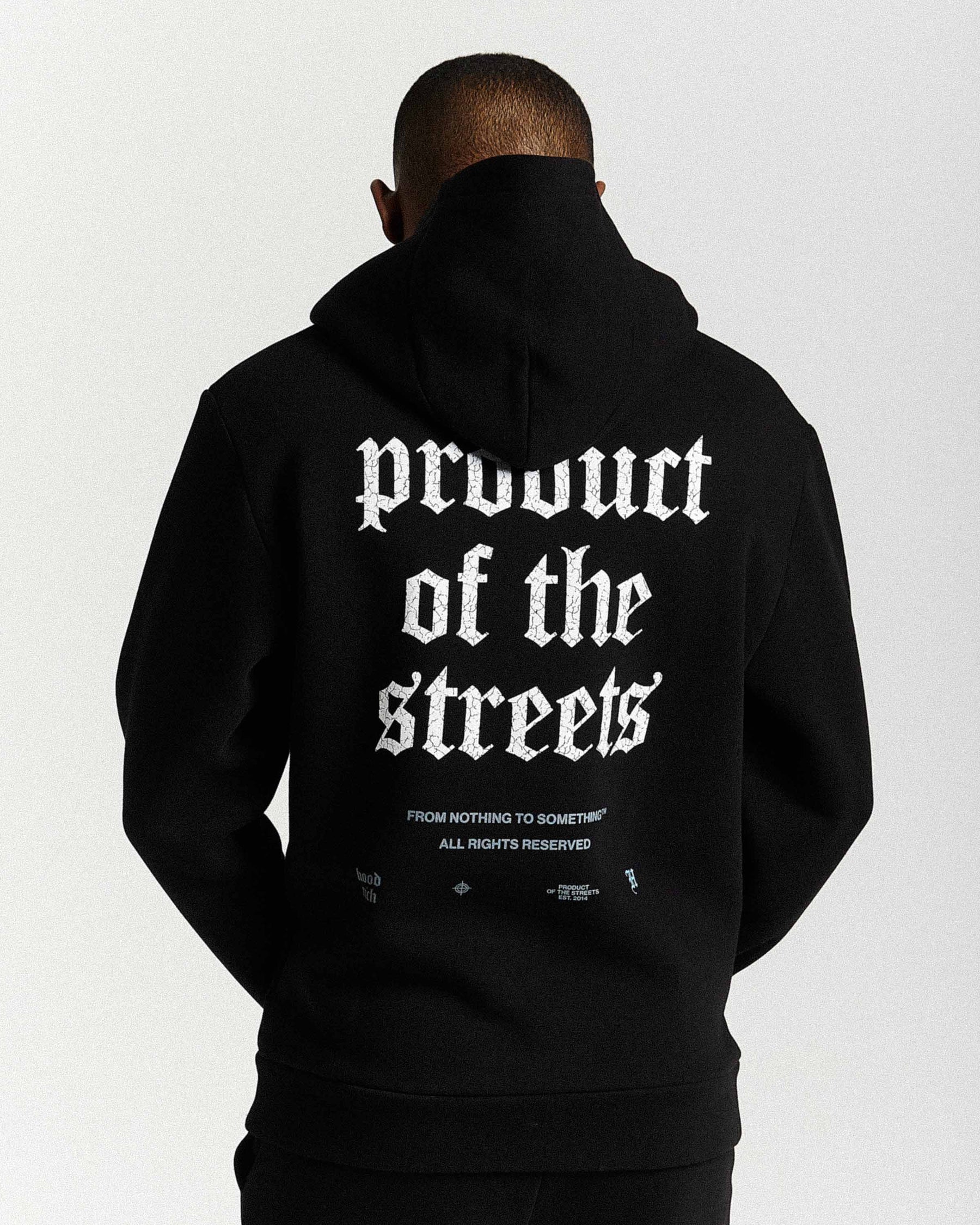 Person wearing a black hoodie with 'Product of the Streets' text on the back against a white background